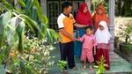 Smallholder farmer’s family standing on the porch of their house.