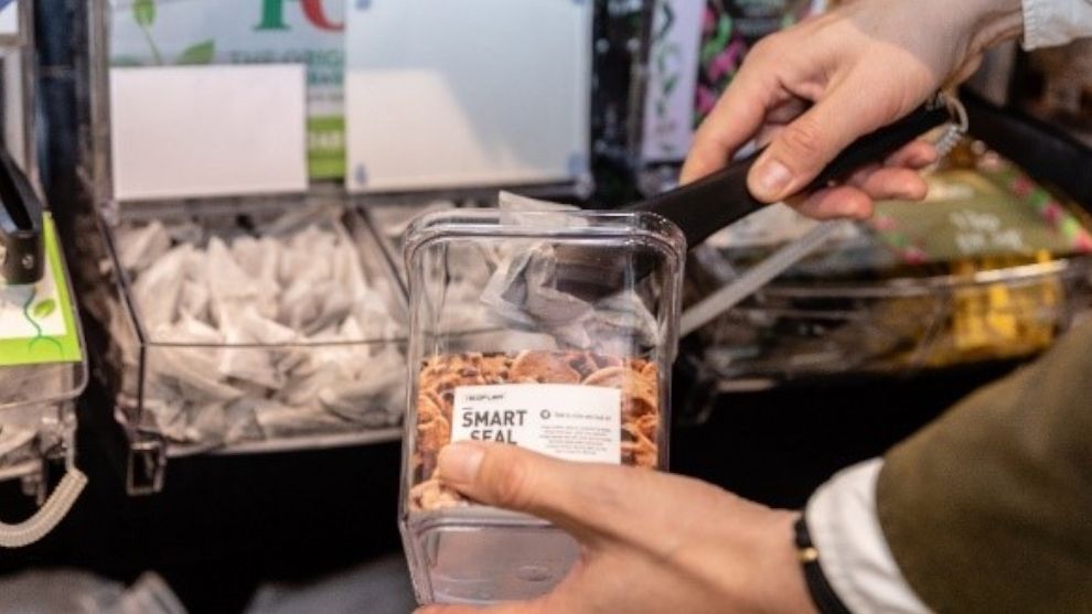An image of the PG Tips refill station, with a customer using a reusable container.