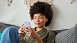 Young African American woman using smartphone at home.