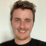 Austin wearing a black t-shirt and smiling at the camera