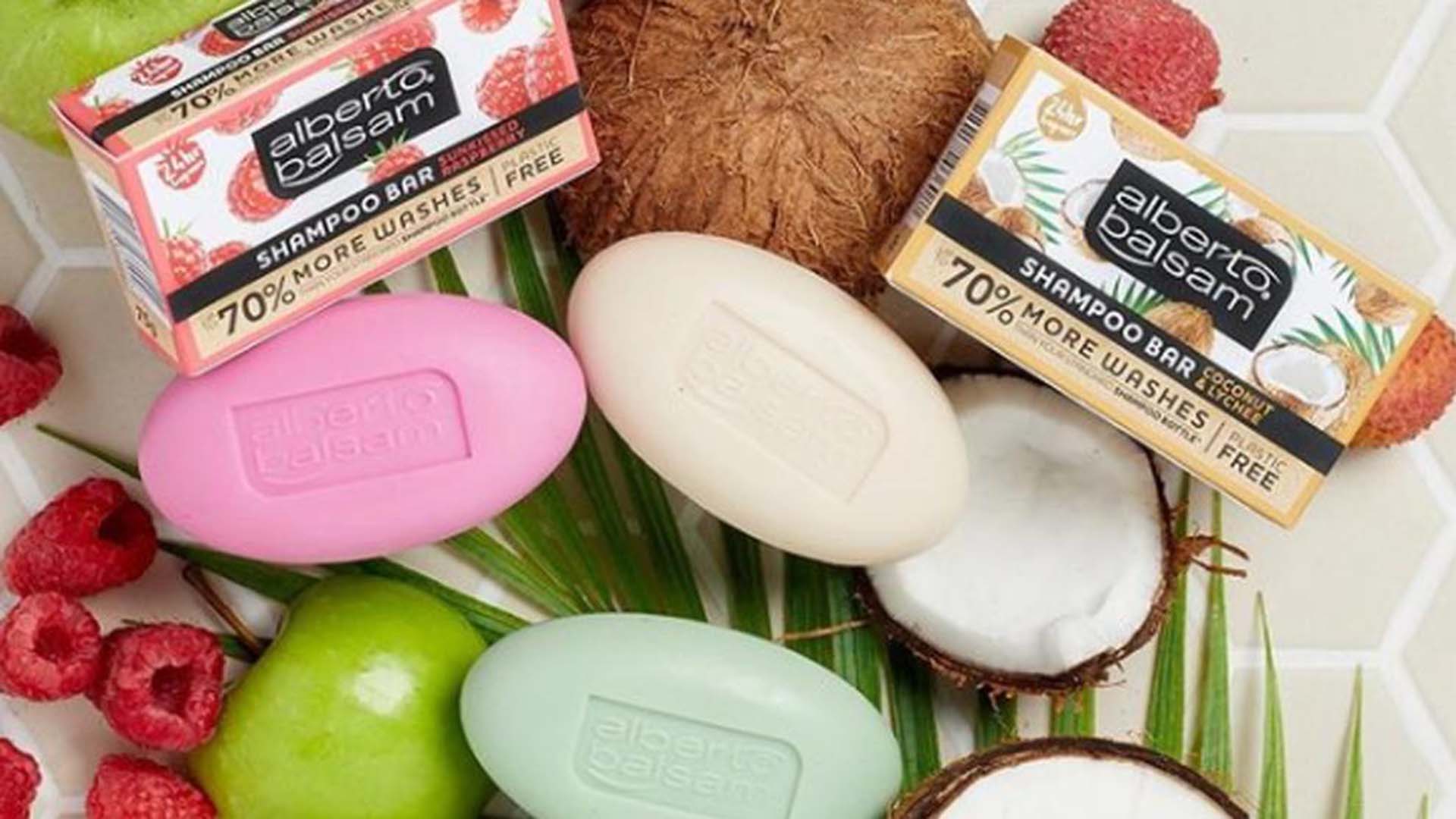 A selection of Alberto Balsam shampoo bars that are 100% plastic-free. The image also shows the coconut, apple and raspberry fruit used to make these bars.