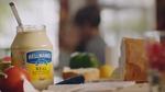 A jar of Hellmans mayonase with bread and tomatos