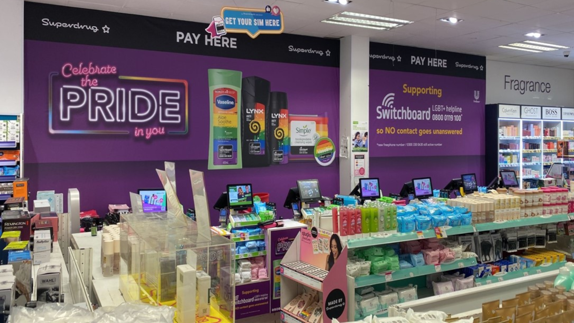 Large 'Celebrate the Pride in you' wall poster showing Pride branded personal care products, and Switchboard contact details.