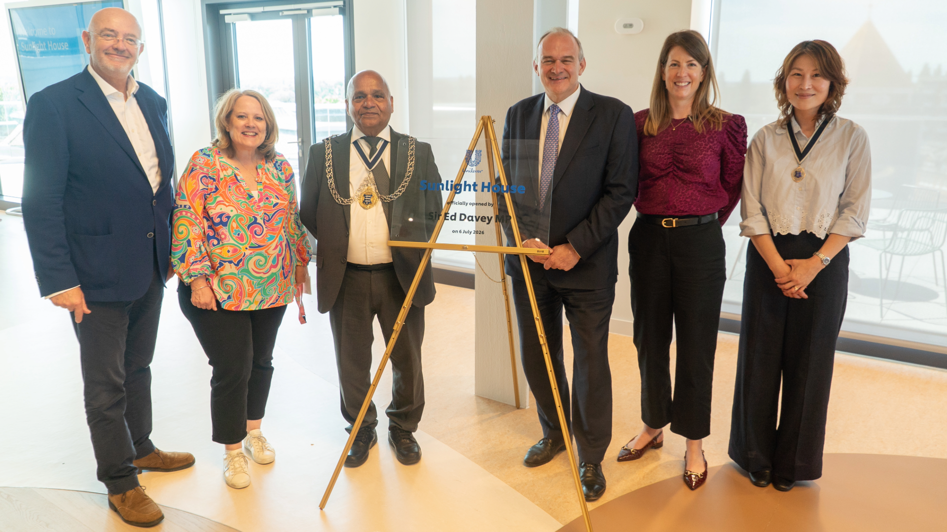 Group of attendees standing beside a commemorative plaque marking the opening of Sunlight House, Unilever's new UK and Ireland headquarters in Kingston upon Thames.