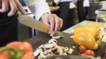 Image of chef in a kitchen cutting up vegetables