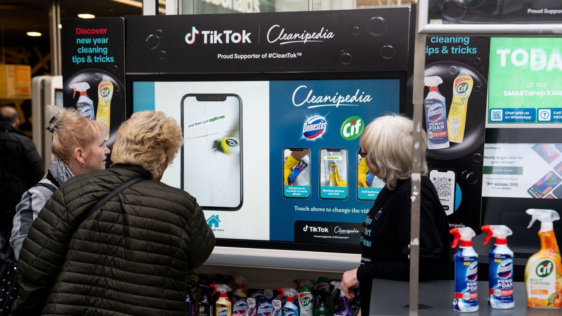 Three women looking at a digital screen.