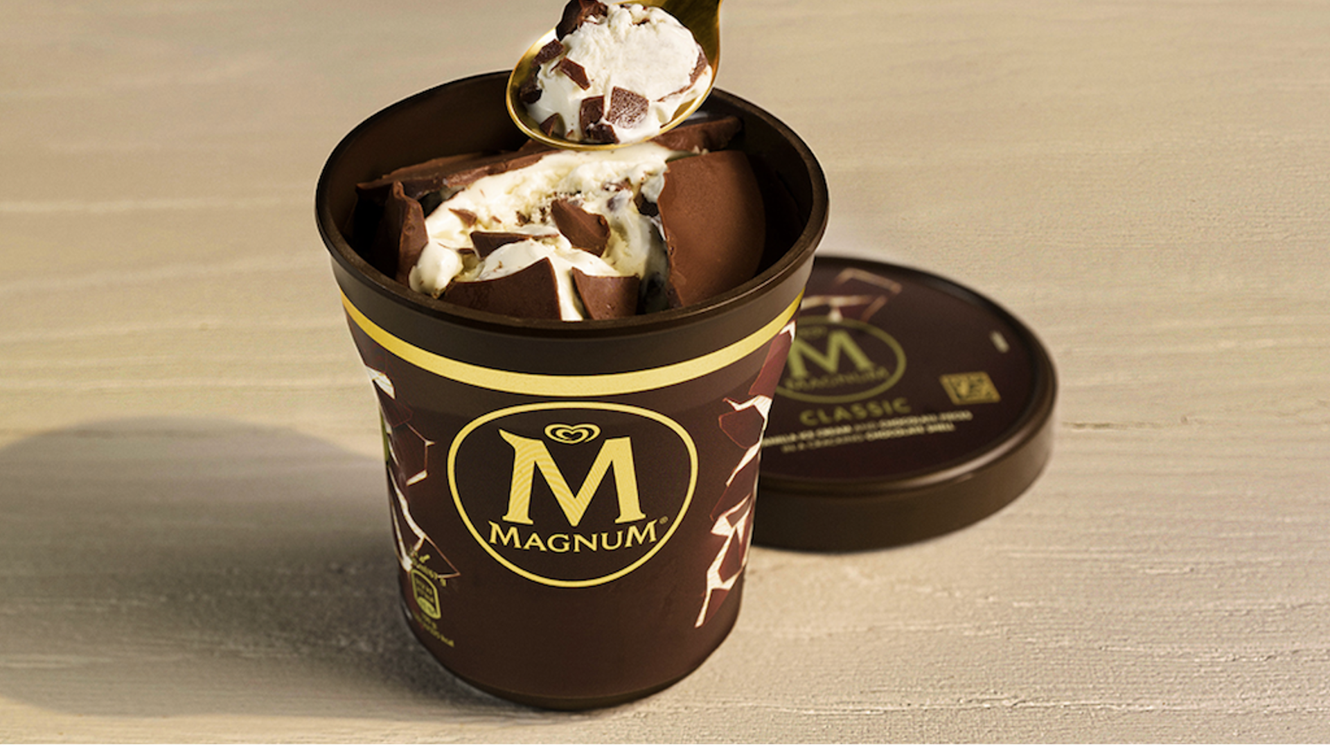 Pack shot of an open cracking chocolate ice cream tub, with Magnum branding